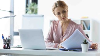 Frau sichtet den Antrag zur Kostenübernahme der Entrümpelung